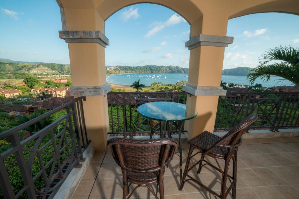 a balcony with a table and chairs and a view of the water at Marbella 3D 3 bdr Ocean View in Los Suenos in Herradura
