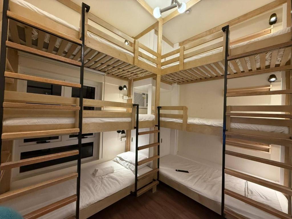 a room with three bunk beds in a hostel at The Camden Place Cozy Family Group Condo Unit in Manila