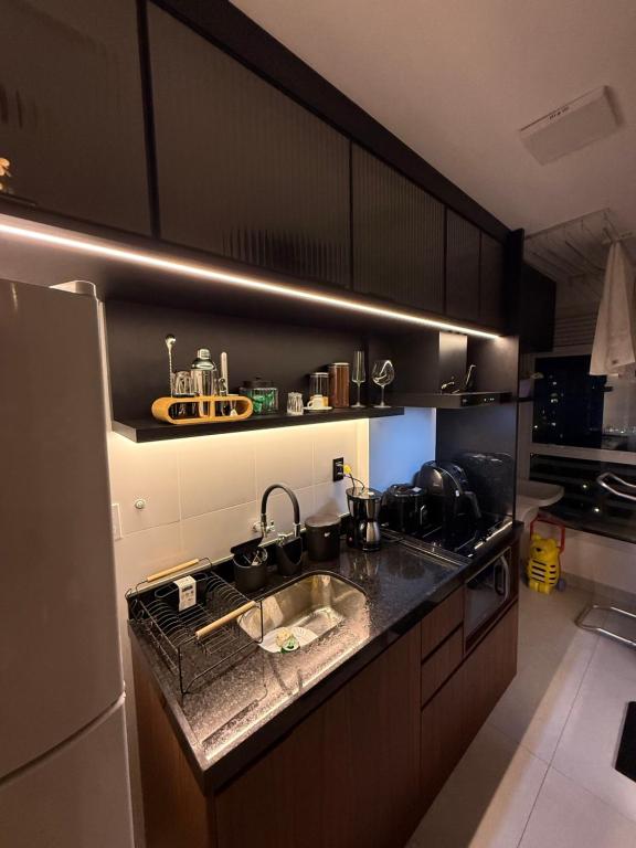 a kitchen with a sink and a refrigerator at Apartamento top em Vila Velha in Vila Velha