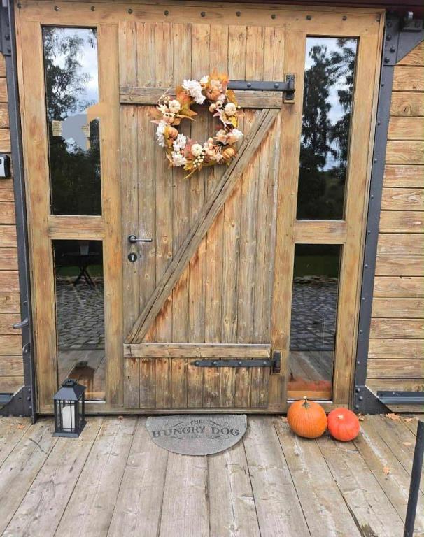 KamberkにあるObytný vagónのポーチに花輪とカボチャが飾られた木製のドア