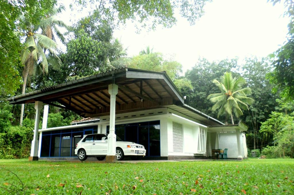 a white car parked in front of a house at Hotel Rays Lanka Avissawella in Avissawella