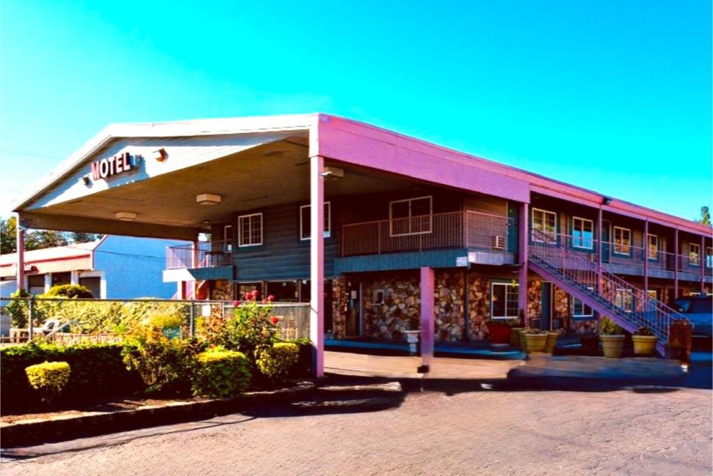 a building with a pink roof and stairs on it at Beaverton Budget Inn in Beaverton