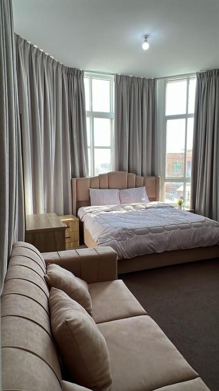 a bedroom with two beds and a couch at Khalifa A Home Stay NR in Abu Dhabi