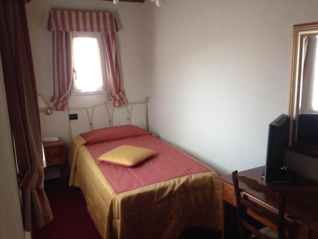 a small bedroom with a bed and a television at Hotel Di Stefano in Pisa