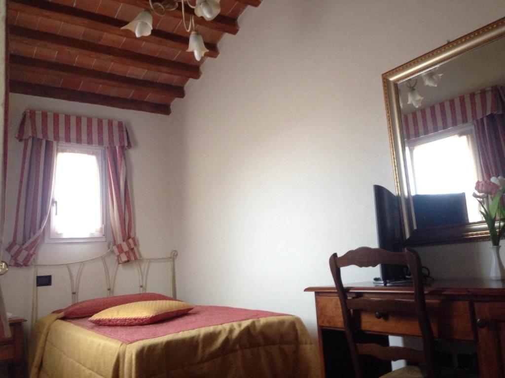 a bedroom with a bed and a mirror and a desk at Hotel Di Stefano in Pisa