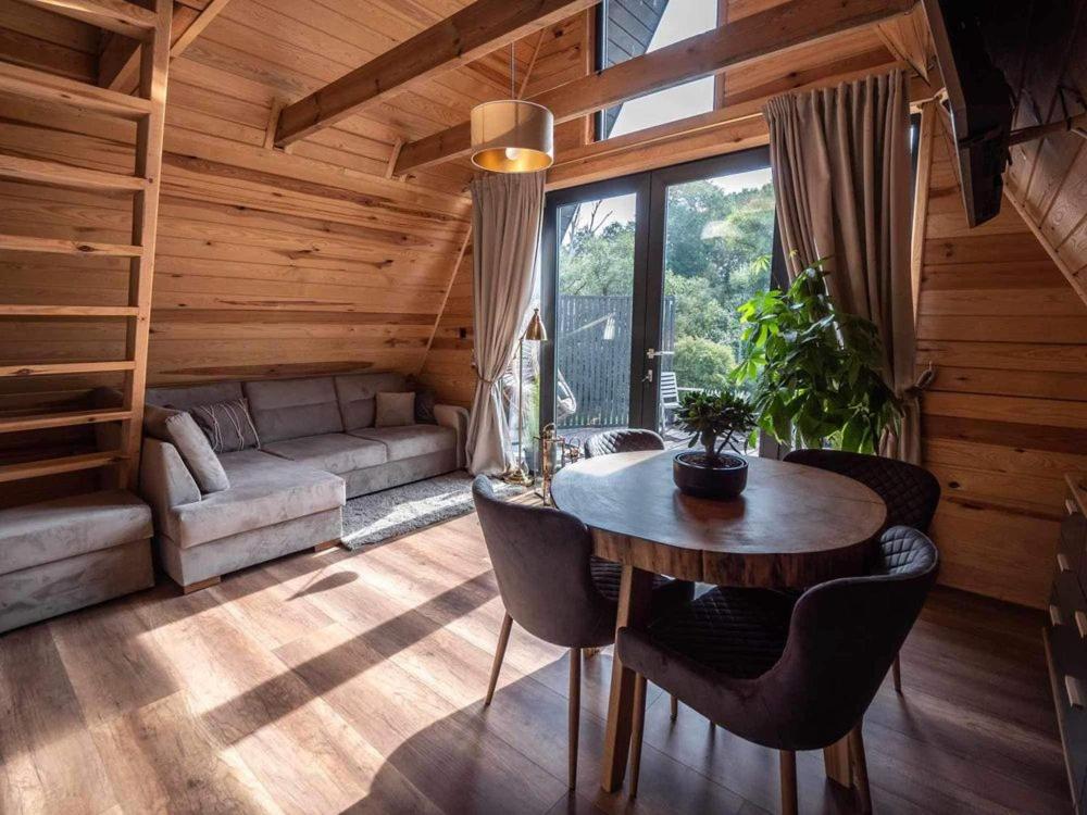 a room with a table and a couch in a cabin at Chill House Wierzchucinek in Wierzchucinek
