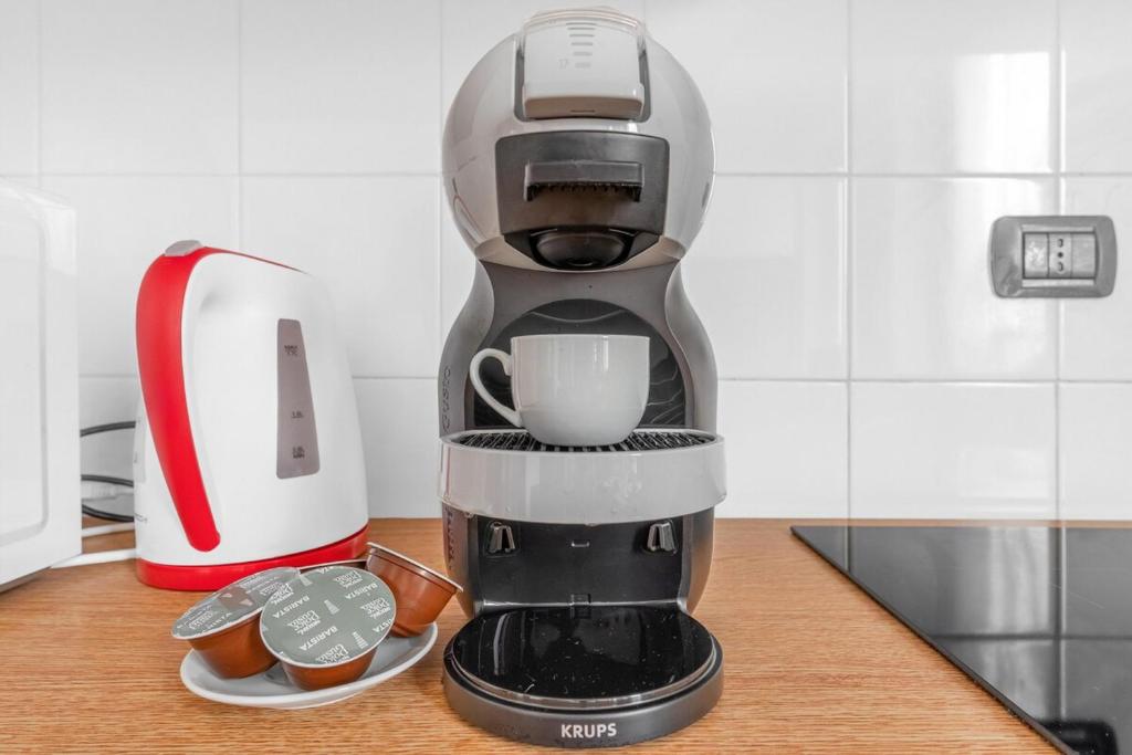 una cafetera sentada en un mostrador con pastelitos en New -20 cozy flat fiera milano 5 min free wifi, en Rho