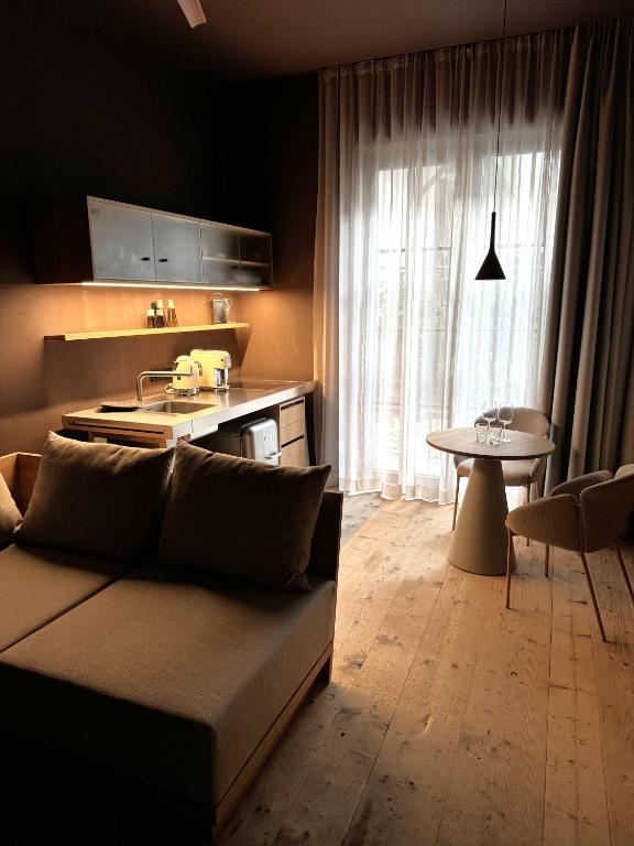 a living room with a couch and a kitchen at La Maison 35 - Bruneck - zentral gelegene Appartments in Brunico