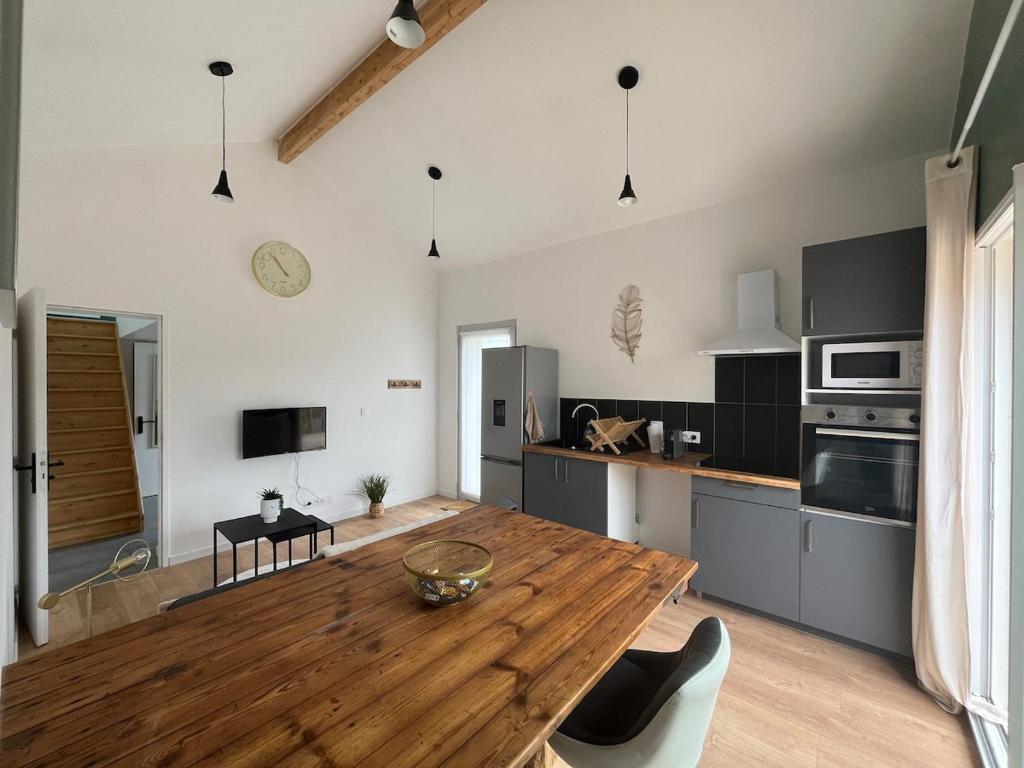 a kitchen with a wooden table in a room at Maison indépendante avec cour privative in Cars