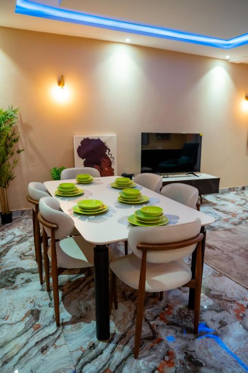 een eetkamer met een witte tafel en stoelen bij Immeuble 30 Juin in Lubumbashi
