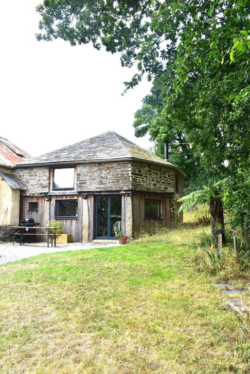 ein Steinhaus mit einem Hof davor in der Unterkunft The Roundhouse, beautiful barn in North Cornwall in North Petherwin