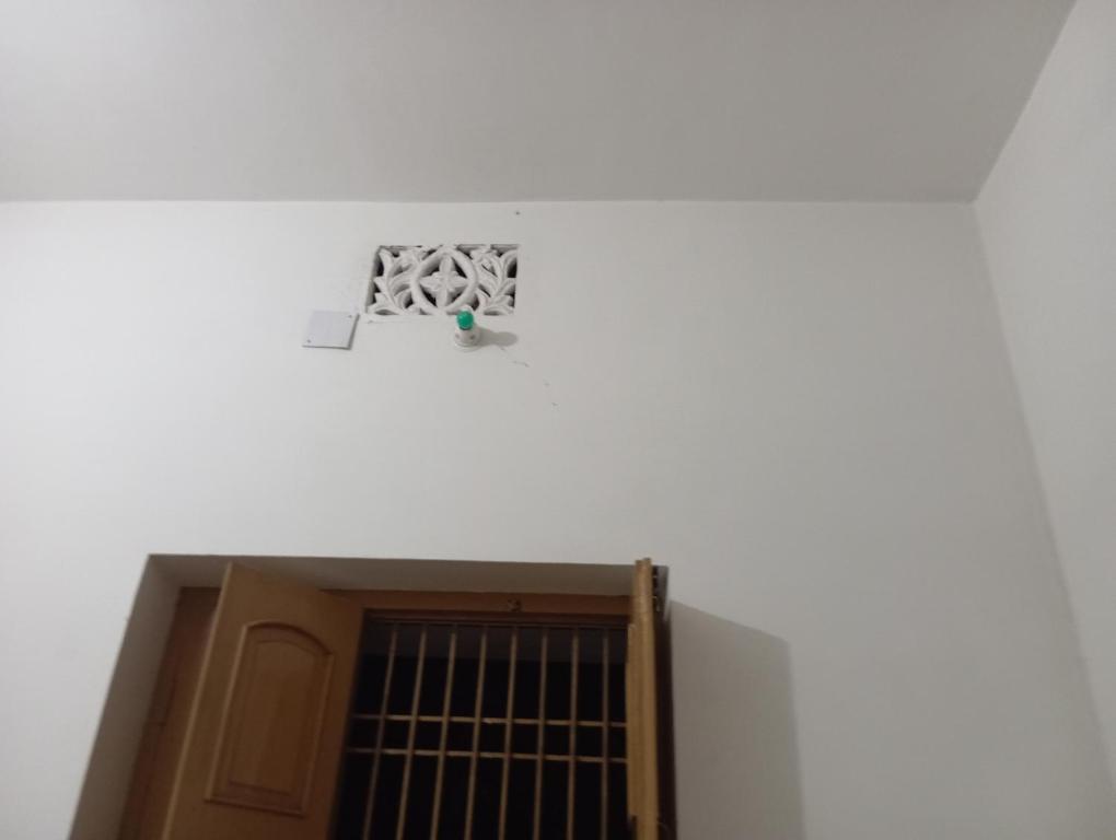 eine Tür in einer weißen Wand mit einem Fenster in der Unterkunft Aadha vatika in Deoghar