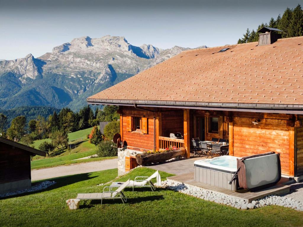 a log cabin with a television on a patio at Pralor Le Nova - OVO Network in Manigod