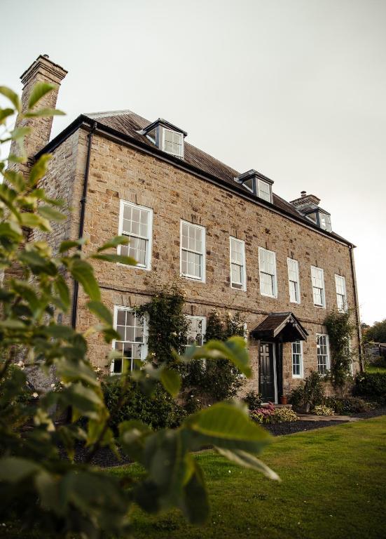 a large brick building with white windows at Stone House Wales in Kington