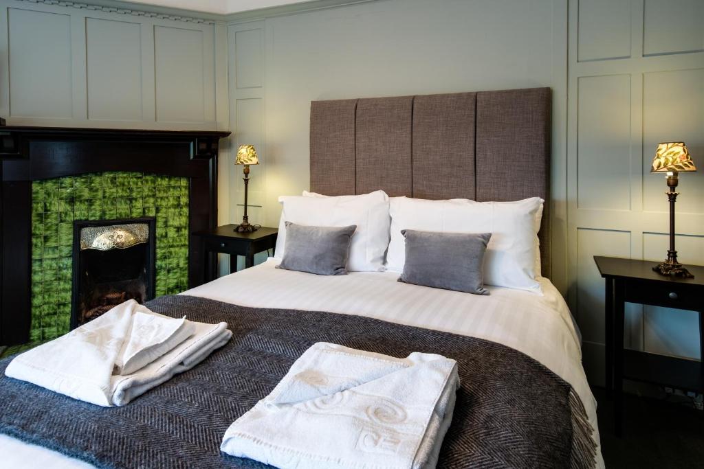 een slaapkamer met een groot bed en 2 handdoeken bij Glenbruar House in Crianlarich
