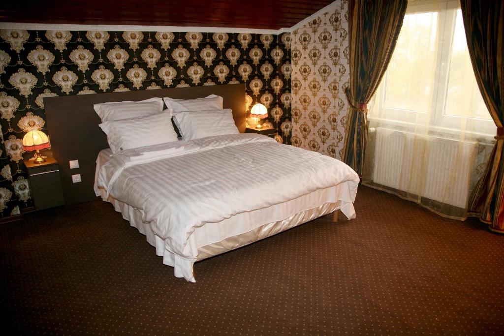 a bedroom with a large bed and a window at Pensiunea Lokanta in Daia