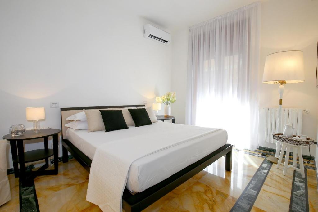 ein Schlafzimmer mit einem großen weißen Bett und einem Fenster in der Unterkunft Starhost - GOLDEN SUITE in Salerno