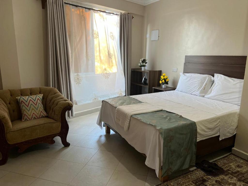 ディアニ・ビーチにあるSunQuine Studioのベッドと椅子と窓のある寝室