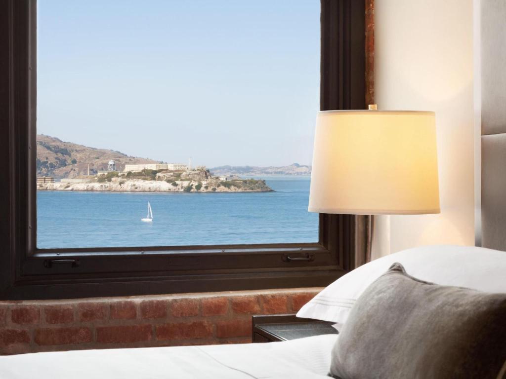 a bedroom with a window with a view of the ocean at The Fairmont Heritage Place Ghirardelli Square in San Francisco