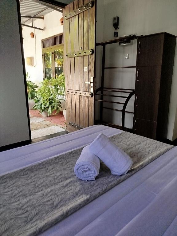 a towel laying on a bed in a bedroom at Step Inn Ahangama in Ahangama