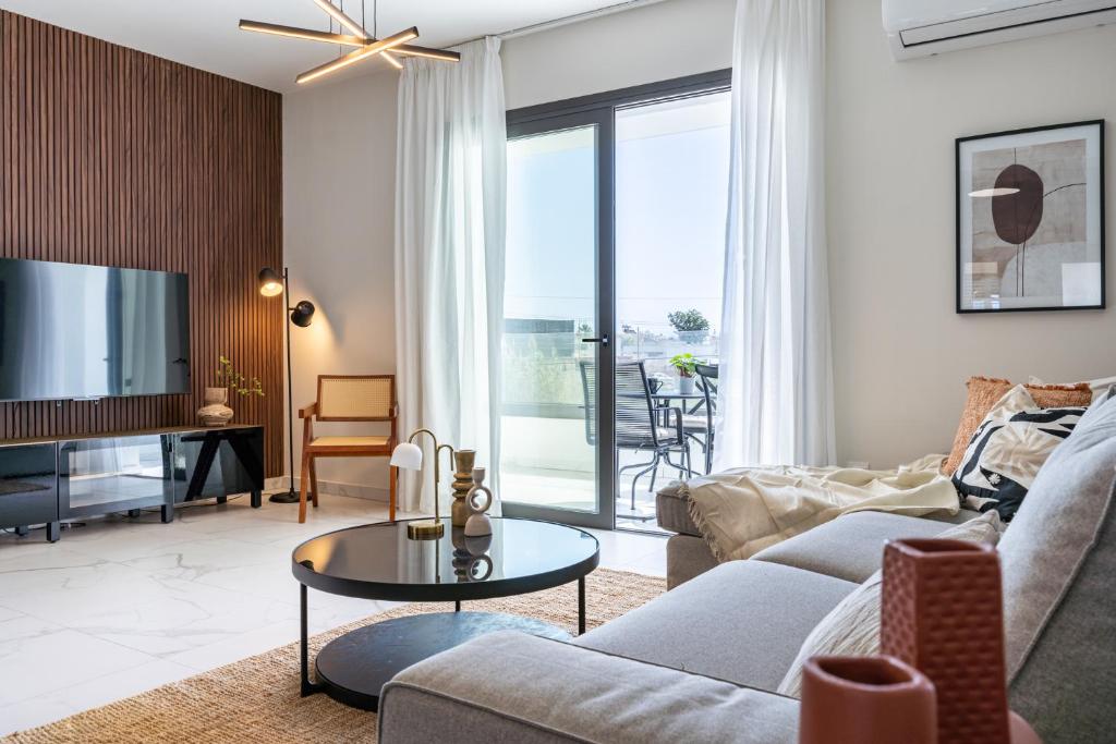 a living room with a couch and a tv at Vervana 2-Bedroom Apartment in Larnaca