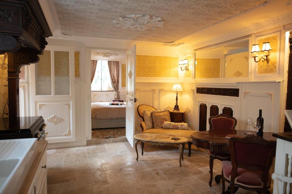 a living room with a couch a table and a bed at Au Petit Chateau les Bains in Morvan in Saint-Honoré-les-Bains