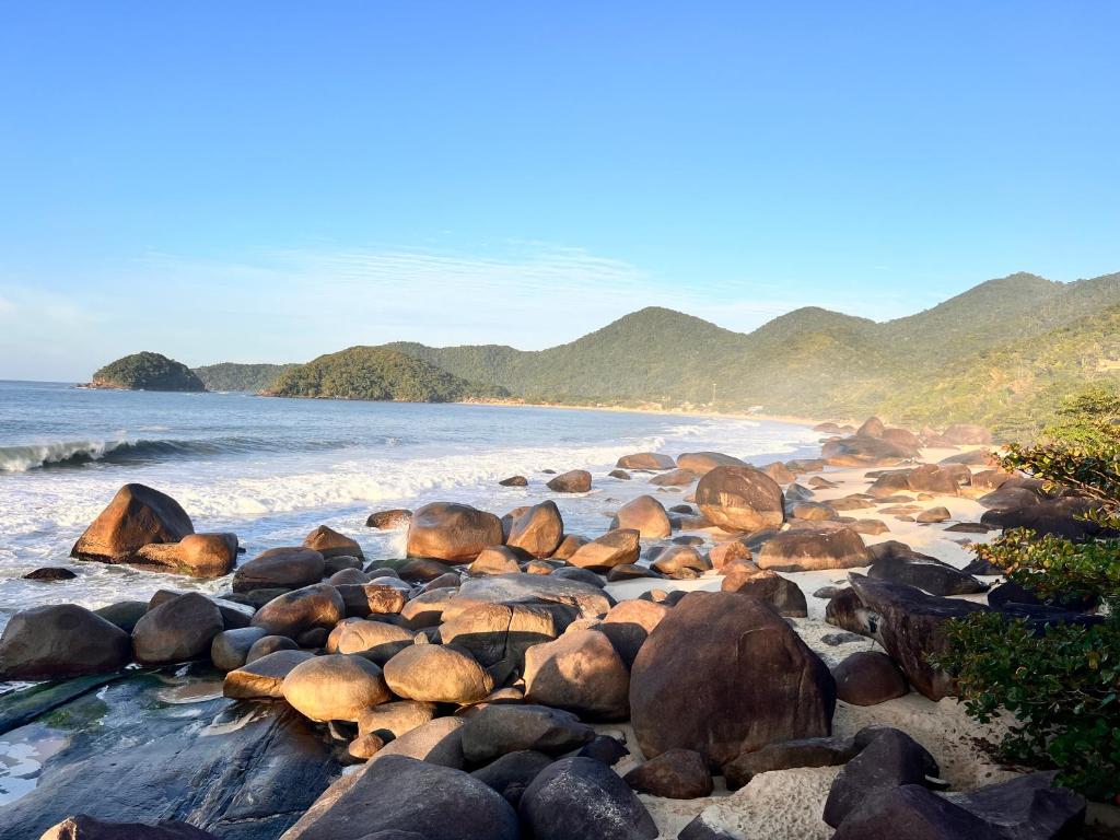 a group of rocks on the shore of a beach at chalés frente à praia in Trindade