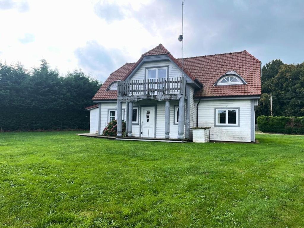 una casa bianca con un grande prato di Domaine des Célestins - Grange aux fées a Bernay-en-Ponthieu