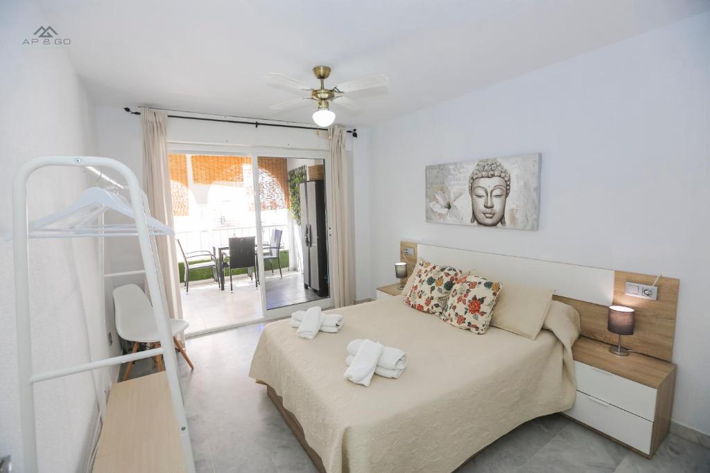 Un dormitorio con una cama con toallas. en Alcazaba Del Mar parking next to the beach, en La Herradura