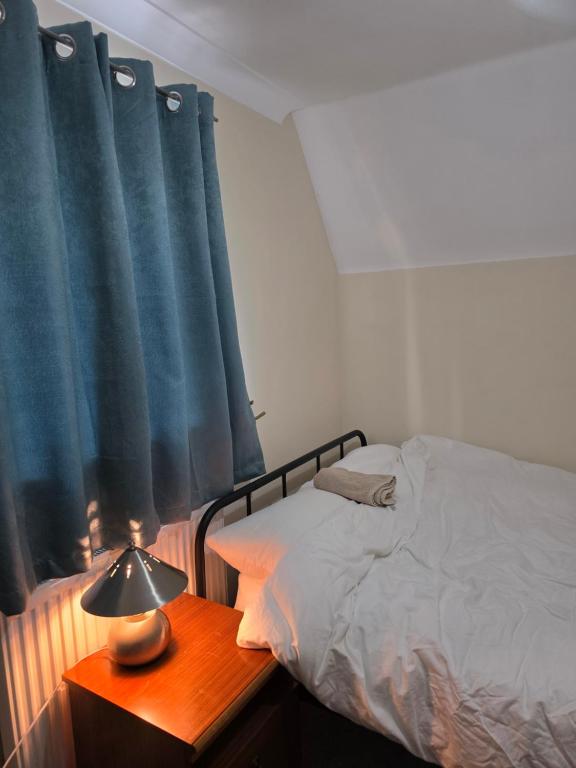 Un dormitorio con una cama y una mesa con una lámpara. en Colchester Comfortable room Oo, en Hythe