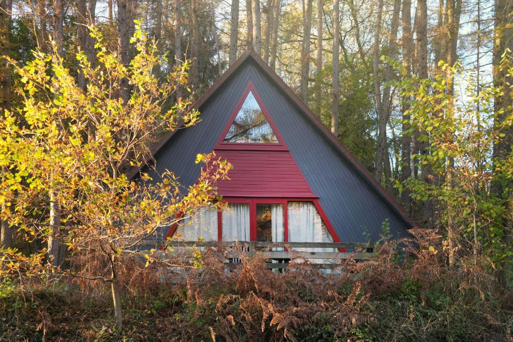 a small red and black house in the woods at Domaine Long Pre in Stavelot