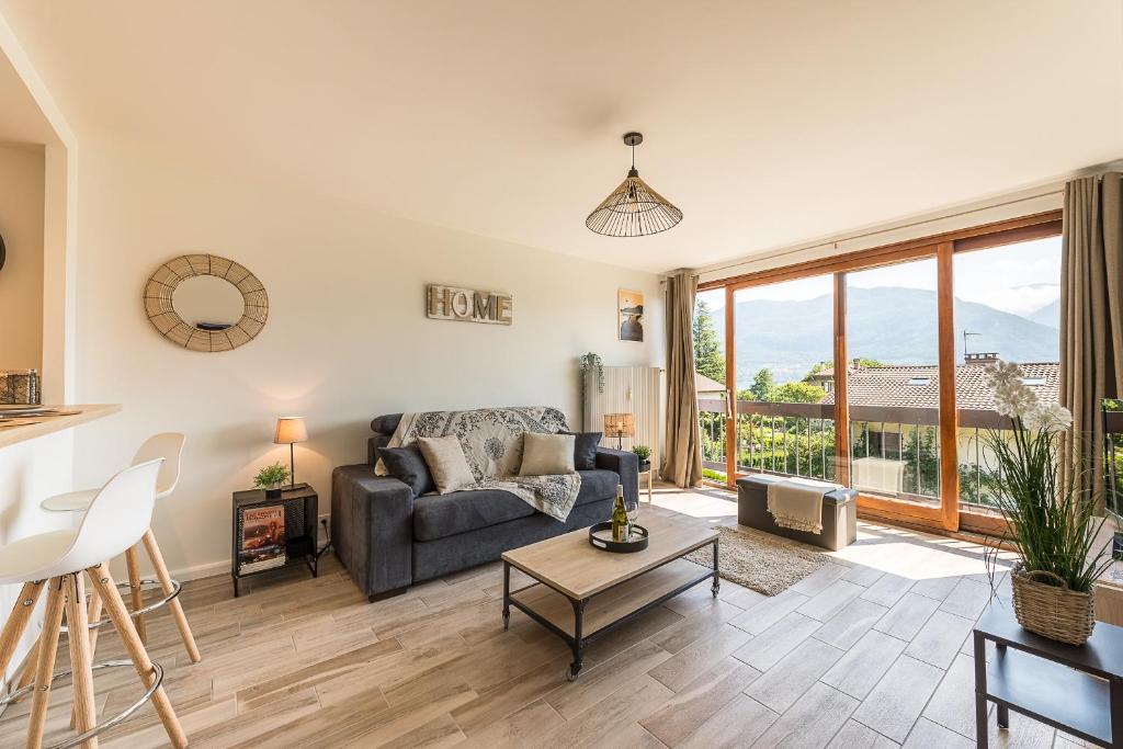 a living room with a couch and a table at Studio Aurore - Charmant logement avec vue montagnes in Sévrier