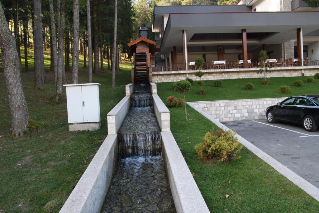 a water fountain in front of a house at Hotel Balkana Vidović in Mrkonjić Grad