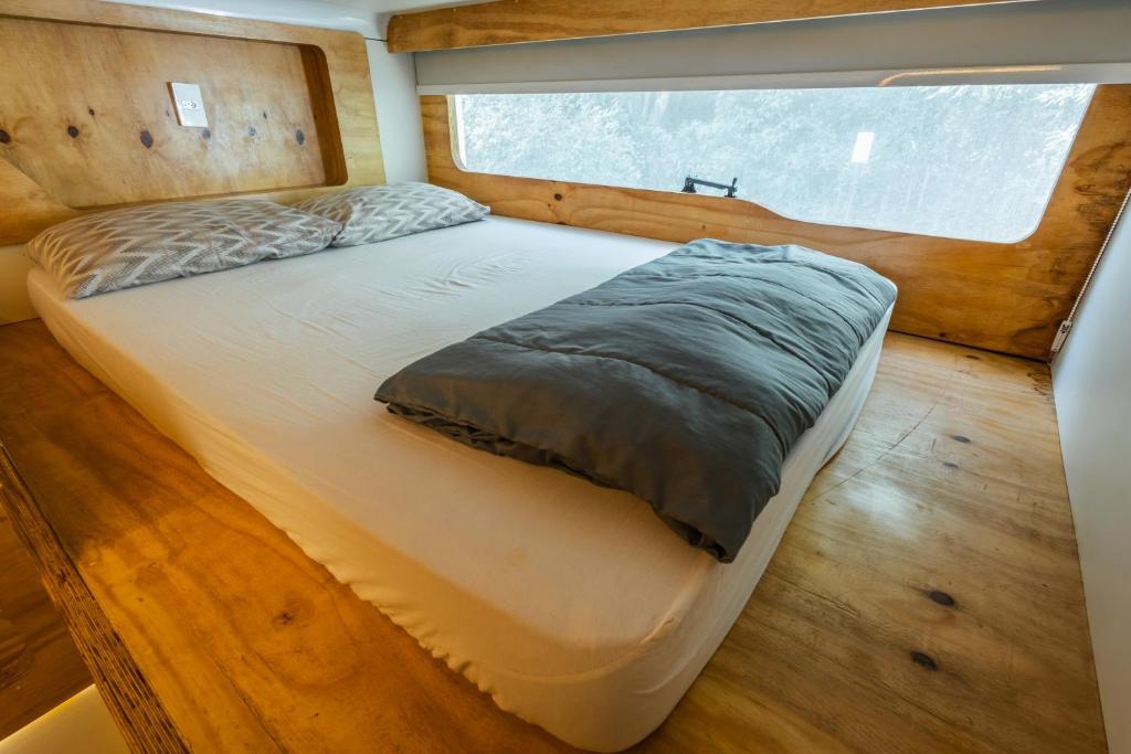 1 cama en el medio de una habitación con ventana en Green Garden Foz - Casas e Lofts em um Bosque, en Foz do Iguaçu