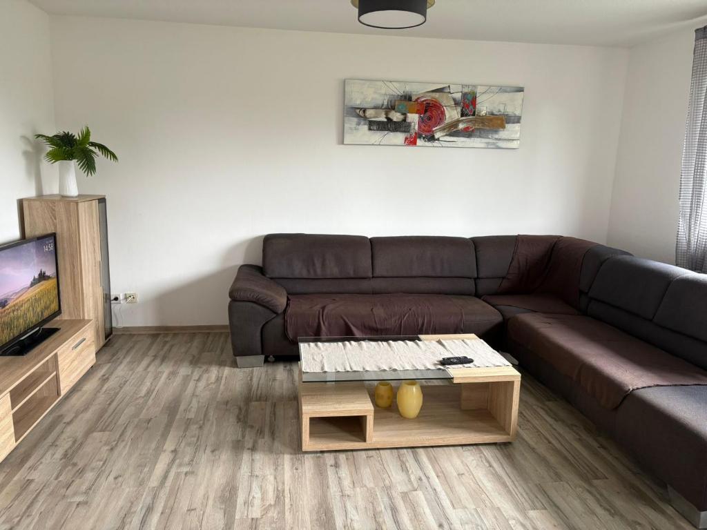 a living room with a brown couch and a tv at Ferienwohnung Werne in Werne an der Lippe