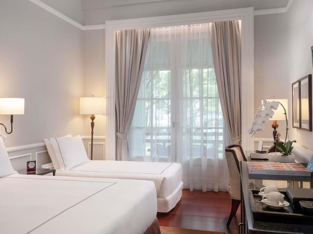 Una cama o camas en una habitación de Raffles Hotel Le Royal