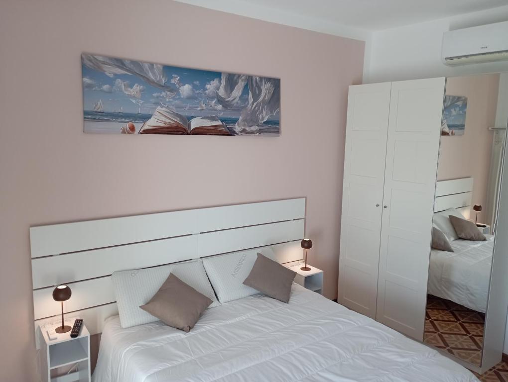 a bedroom with a white bed and a painting on the wall at Alloggio San Francesco in Peschiera del Garda