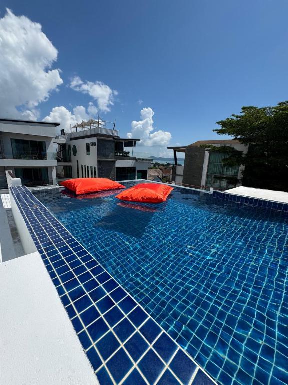 a swimming pool with red pillows on top of a building at Villa Rooftop in Ban Saiyuan (1)
