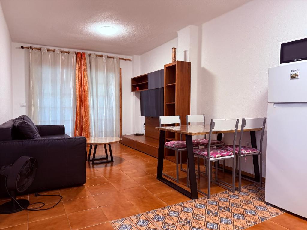 ein Wohnzimmer mit Esstisch und Küche in der Unterkunft Garden City in Playa Fañabe