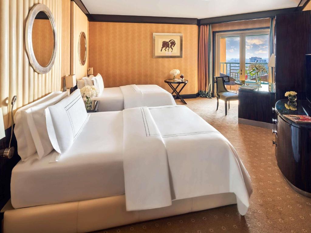 a large white bed in a hotel room at Fairmont Nile City in Cairo
