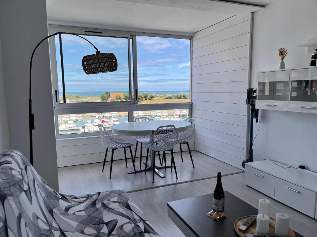 a room with a table and chairs and a window at La Coquille - Coquet T2 à 200m Juno Beach & Plage in Courseulles-sur-Mer