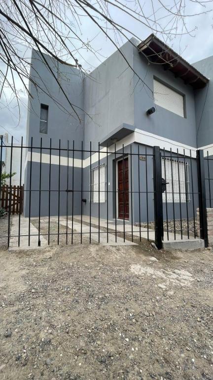 a building with a fence in front of it at Casa Paso in Puerto Madryn