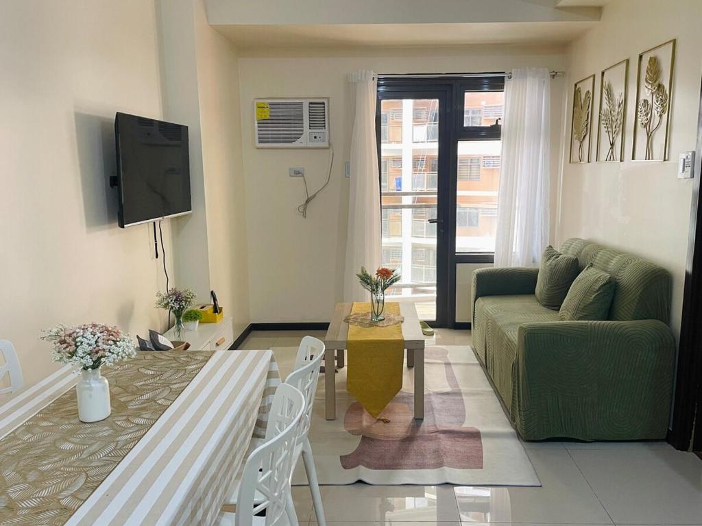 ein Wohnzimmer mit einer grünen Couch und einem Tisch in der Unterkunft Baylight Studio in Sampong