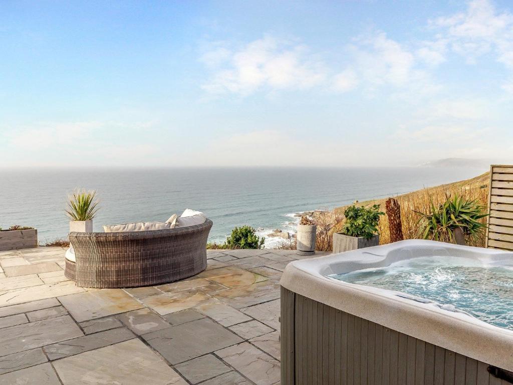 a hot tub on a patio overlooking the ocean at 2 Bed in Whitsand Bay 91328 in Antony