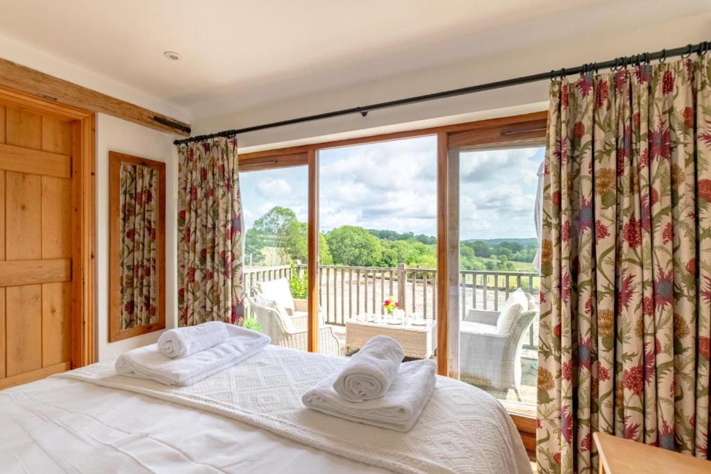 a bedroom with a bed and a large window at Dairy Cottage in Wadhurst