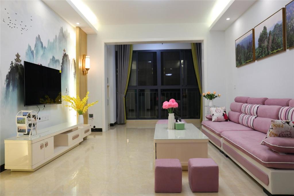 a living room with a pink couch and a tv at Zhangjiajie 72 Wonder Tower Neighbour's House in Zhangjiajie