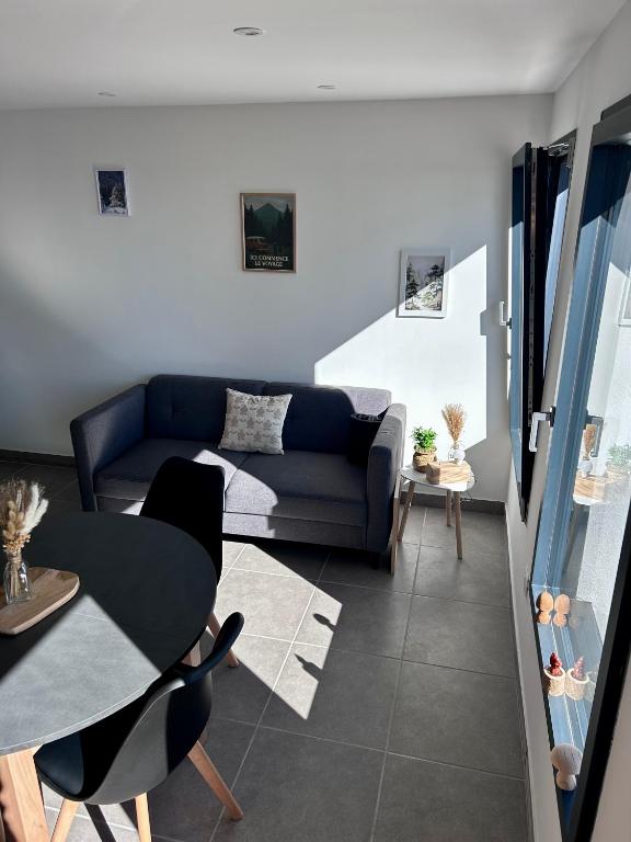 a living room with a couch and a table at Les Gîtes de la Source de la Loire in Sainte-Eulalie