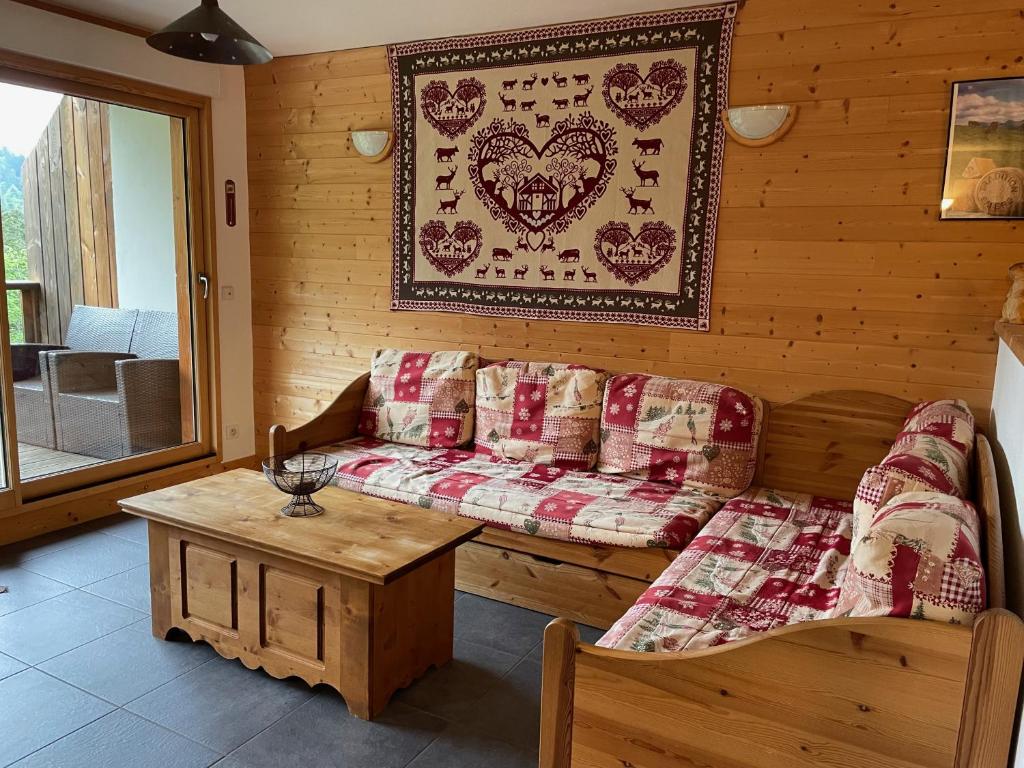 uma sala de estar com um sofá e uma mesa em Rocher du Cerf skis aux pieds 3 ch 2 sdb em Le Lioran
