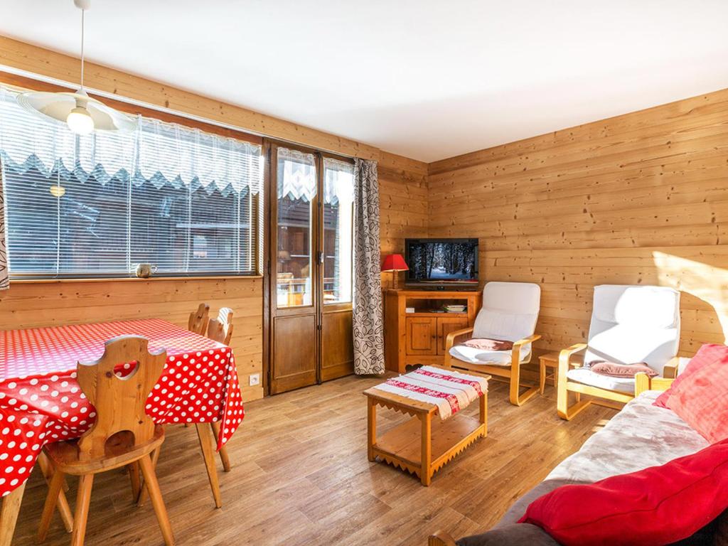 a living room with wooden walls and a table and chairs at Appartement 2 chambres centre village proche pistes avec Wifi - FR-1-437-60 in La Clusaz