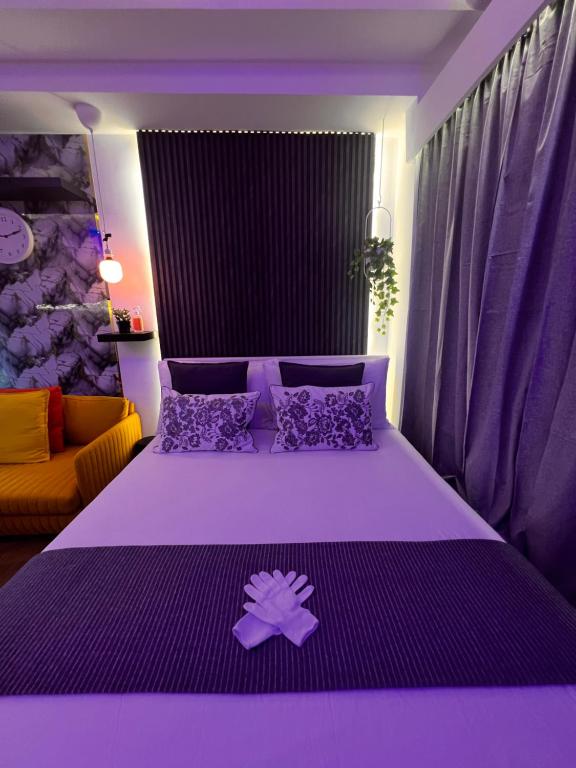 een paarse slaapkamer met een groot bed met paarse kussens bij Zhafira Retreat in Manilla